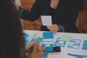 Close up ux developer and ui designer use augmented reality brainstorming about mobile app interface wireframe design on desk at modern office.Creative digital development agency photo