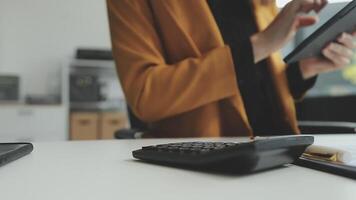 jovem confiante bem sucedido empresária usando computador portátil e digital tábua, focado em trabalhar, criando o negócio estratégia planos em tábua. fêmea o negócio profissional distante trabalhando conectados a partir de lar. video