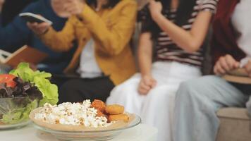 lunch, gelukkig vrienden en pizza partij met voedsel, drankjes en gesprek, sociaal bijeenkomst en krijgen samen. jong mensen, groep en geluk Bij snel voedsel pizzeria, restaurant en viering Bij huis video