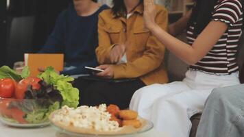 lunch, gelukkig vrienden en pizza partij met voedsel, drankjes en gesprek, sociaal bijeenkomst en krijgen samen. jong mensen, groep en geluk Bij snel voedsel pizzeria, restaurant en viering Bij huis video