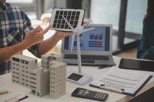 eléctrico ingeniero con empresario que se discute nuevo proyecto instalación solar célula panel en el techo de edificio. alternativa energía concepto. foto