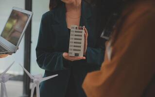 Electrical engineer with businessman discussing new project installation solar cell panel on the roof of building. Alternative energy concept. photo