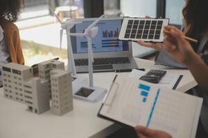 Electrical engineer with businessman discussing new project installation solar cell panel on the roof of building. Alternative energy concept. photo