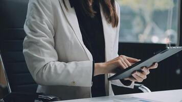 jovem confiante bem sucedido empresária usando computador portátil e digital tábua, focado em trabalhar, criando o negócio estratégia planos em tábua. fêmea o negócio profissional distante trabalhando conectados a partir de lar. video