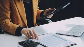 jong zelfverzekerd geslaagd zakenvrouw gebruik makend van laptop en digitaal tablet, gefocust Aan werk, creëren bedrijf strategie plannen Aan tablet. vrouw bedrijf professioneel ver weg werken online van huis. video