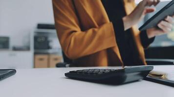 jovem confiante bem sucedido empresária usando computador portátil e digital tábua, focado em trabalhar, criando o negócio estratégia planos em tábua. fêmea o negócio profissional distante trabalhando conectados a partir de lar. video