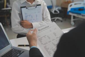 Close up view of job interview in office, focus on resume writing tips, employer reviewing good cv of prepared skilled applicant, recruiter considering application, hr manager making hiring decision photo