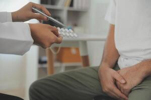 Male diseases. Man presses hands to his groin and suffering from pain, panorama, cropped, studio shot photo