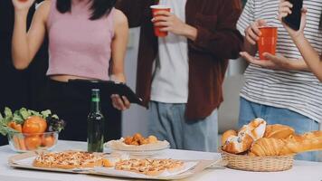 lunch, gelukkig vrienden en pizza partij met voedsel, drankjes en gesprek, sociaal bijeenkomst en krijgen samen. jong mensen, groep en geluk Bij snel voedsel pizzeria, restaurant en viering Bij huis video