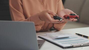 Insurance officers hand over the car keys after the tenant. have signed an auto insurance document or a lease or agreement document Buying or selling a new or used car with a car video