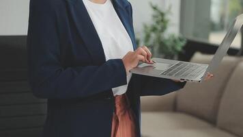 asiatische geschäftsfrau, die laptop-computer verwendet und im büro mit taschenrechnerdokument auf schreibtisch arbeitet, plant die analyse des finanzberichts, geschäftsplaninvestitionen, finanzanalysekonzept. video