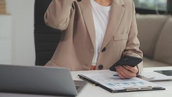 empresária asiática usando computador portátil e trabalhando no escritório com documento de calculadora na mesa, fazendo planejamento analisando o relatório financeiro, investimento em plano de negócios, conceito de análise financeira. video