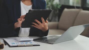 femme d'affaires asiatique utilisant un ordinateur portable et travaillant au bureau avec un document de calculatrice sur le bureau, faisant la planification en analysant le rapport financier, l'investissement dans le plan d'affaires, le concept d'analyse financière. video