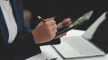 mujer de negocios asiática que usa una computadora portátil y trabaja en la oficina con un documento de calculadora en el escritorio, planificando el análisis del informe financiero, la inversión del plan de negocios, el concepto de análisis financiero. video