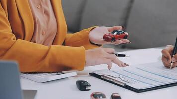 Insurance officers hand over the car keys after the tenant. have signed an auto insurance document or a lease or agreement document Buying or selling a new or used car with a car video