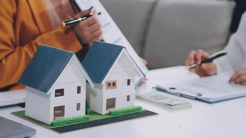 husmodell med agent och kund som diskuterar för avtal om att köpa, få försäkring eller låna fastigheter eller fastigheter. video