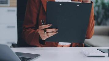 Bookkeeping. Busy millennial indian woman professional accountant preparing annual financial report checking result on calculator. Mixed race female freelancer counting tax rates declaring income video