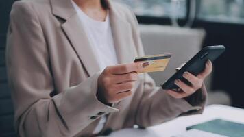 el mujer trabajos a hogar y usos un inteligente teléfono y un cuaderno ordenador portátil computadora. silueta de un ocupado mujer. ella sostiene y utilizando teléfono. video