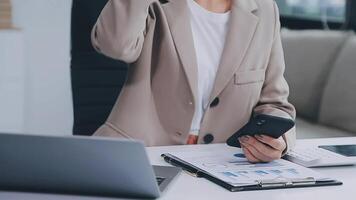 The woman works at home and uses a smart phone and a notebook laptop computer. Silhouette of a busy woman. She holds and using phone. video