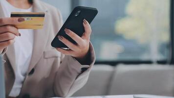 el mujer trabajos a hogar y usos un inteligente teléfono y un cuaderno ordenador portátil computadora. silueta de un ocupado mujer. ella sostiene y utilizando teléfono. video