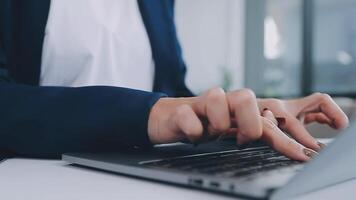 Woman working with laptop at table indoors, closeup video