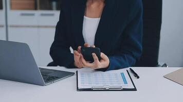 The woman works at home and uses a smart phone and a notebook laptop computer. Silhouette of a busy woman. She holds and using phone. video