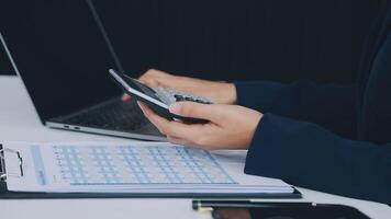 The woman works at home and uses a smart phone and a notebook laptop computer. Silhouette of a busy woman. She holds and using phone. video