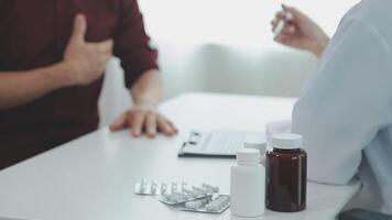 soins de santé, gériatrique médecine, médical vérifier en haut. Sénior homme visite médecin dire à propos santé plaintes, femelle gp l'écriture personnel information, remplissage forme attentivement écoute à personnes âgées patient video