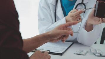 Healthcare, Geriatric Medicine, Medical Check Up. Senior man visiting doctor tell about health complaints, female gp writing personal information, filling form attentively listening to elderly patient video