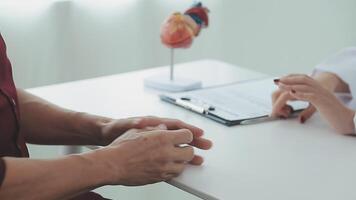 cuidado de la salud, geriátrico medicamento, médico cheque arriba. mayor hombre visitando médico contar acerca de salud quejas, hembra gp escritura personal información, relleno formar atentamente escuchando a mayor paciente video