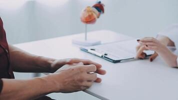 cuidado de la salud, geriátrico medicamento, médico cheque arriba. mayor hombre visitando médico contar acerca de salud quejas, hembra gp escritura personal información, relleno formar atentamente escuchando a mayor paciente video