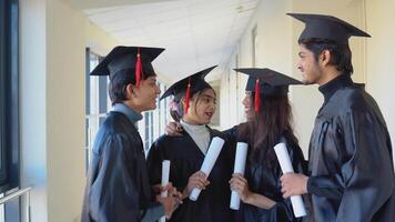 uma grupo do indiano alunos com diplomas comunicar dentro a universidade construção video