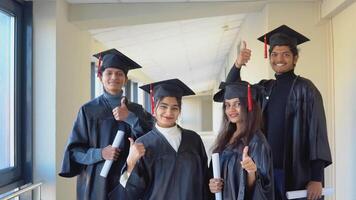 A group of indian students with diplomas stand in the university building video