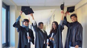 A group of indian students with diplomas stand in the university building video