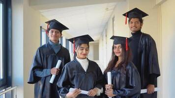 indio Universidad graduados estar en frente de el cámara en maestría sombreros y negro batas video