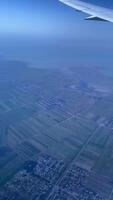 vertical vídeo desde el avión ventana en sus ala y el suelo debajo eso video