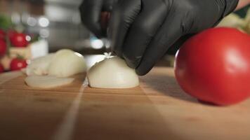 Chef cutting onion with knife on cutting board video