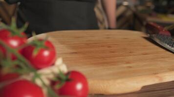 du chef Coupe planche dans le sien cuisine avec tomates, herbes et des légumes mensonge proche video