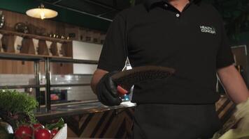 Chef tosses and catches a large knife in his kitchen video