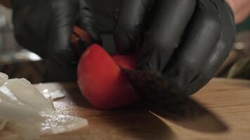 Chef cutting tomato with knife on cutting board video