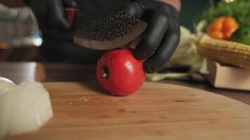 Chef cutting tomato with knife on cutting board video