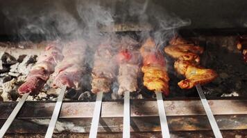 Chicken, meat and liver kebabs are fried on an open grill with charcoal video