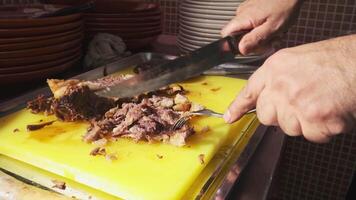 The chef cuts the cooked meat with a knife on a cutting board and puts it on a plate with pilaf video