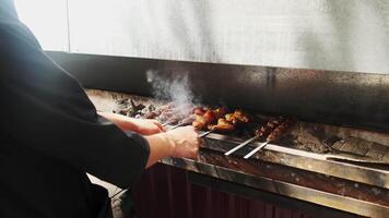 une kebab fabricant se tourne plus de brochettes de poulet, Viande, foie et des légumes frit sur le gril video