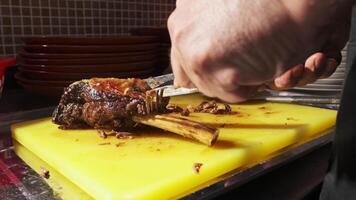 chefe de cozinha corte cozinhou peças do carne para Arroz a grega com uma faca em uma corte borda video