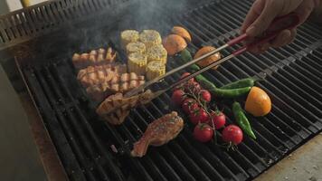 cocinero voltear pescado y A la parrilla vegetales A la parrilla terminado un abierto fuego video