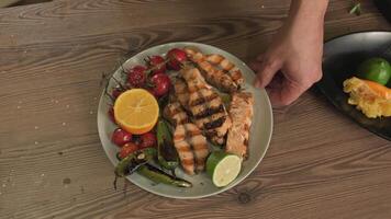 le chef démontre une assiette servi avec frit poisson, herbes, des légumes et citron video