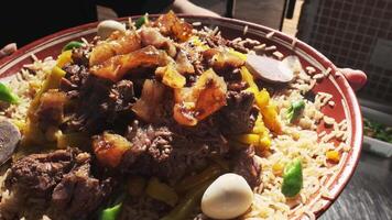 servido plato con uzbeko pilaf con arroz, carne y zanahorias. video
