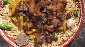 servido plato con uzbeko pilaf con arroz, carne y zanahorias. video