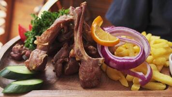 The chef demonstrates a wooden board served with cooked meat, onions, herbs, tomatoes and vegetables video